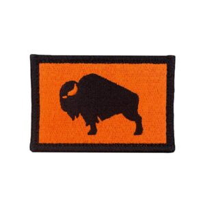 An embroidered 2"X 3" patch that has an American Bison, Buffalo, Ox, bull, with a velcro hook and loop backing. The Bison is black with a safety orange background and black boarder. Tactical gear accessories. Very Popular.