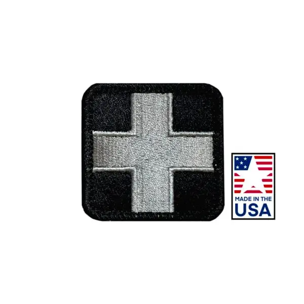 Black and gray 2x2 inch embroidered medical patch featuring a red cross design, hook and loop backing, made in USA for healthcare uniforms.